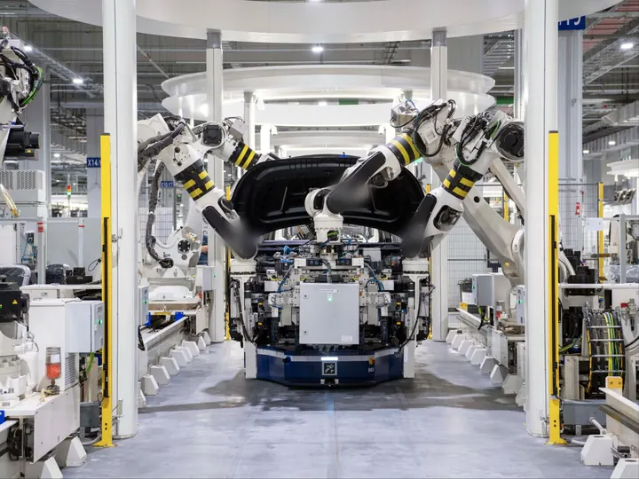 Robots assembling body parts on a car assembly line